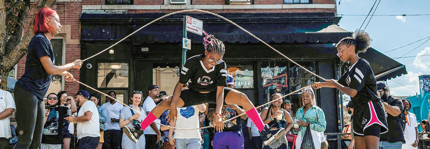 Photo of a crowd gathered to see teens double dutch jump roping